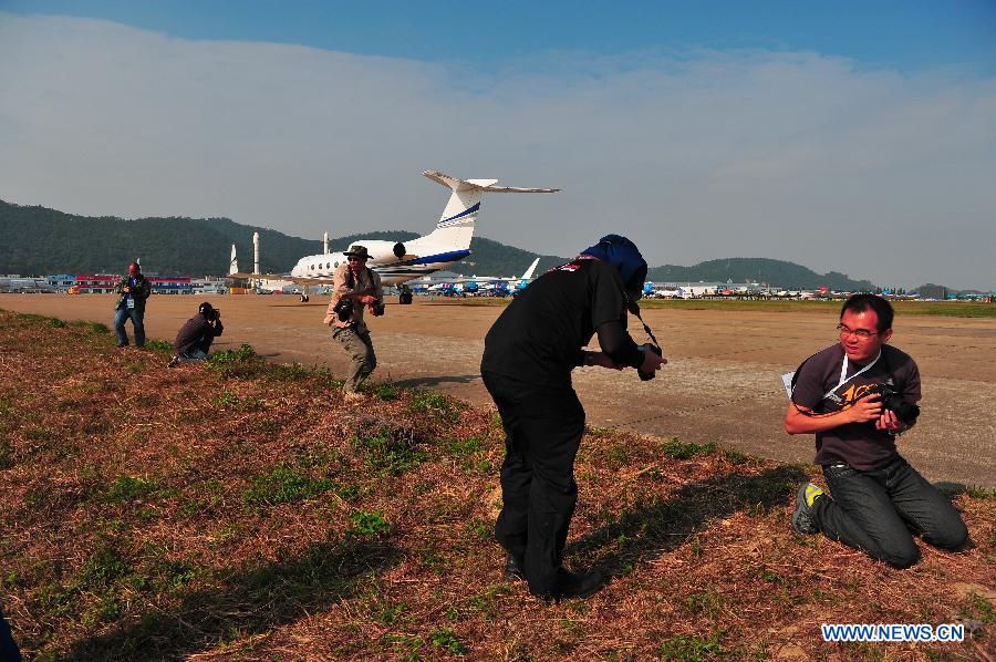 Photographers take photo of a corporate aircraft from Gulfstream during the 9th China International Aviation and Aerospace Exhibition in Zhuhai, south China's Guangdong Province, Nov. 11, 2012. The exhibition has attracted a large number of photograghers. Some of them are from media, some are from aviation industry corporations and others are big fans of aviation. (Xinhua/Yang Guang)