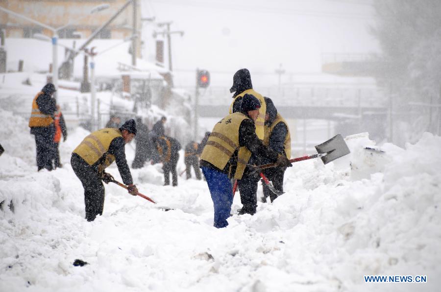 Working staff clean snow piled aside tracks at the Hegang Railway Station in Hegang, northeast China's Heilongjiang Province, Nov. 13, 2012. Heavy snowstorms swept northeastern regions of Heilongjiang since last Sunday, forcing highways to close. Local authority of railway service initiated an emergency plan to maintain order of stranded passengers. (Xinhua/Wang Kai) 