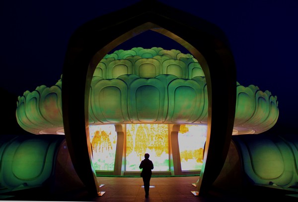 A visitor walks toward a glowing lotus flower at Dayuan Cultural Garden. (Photo: CRIENGLISH.com/William Wang)