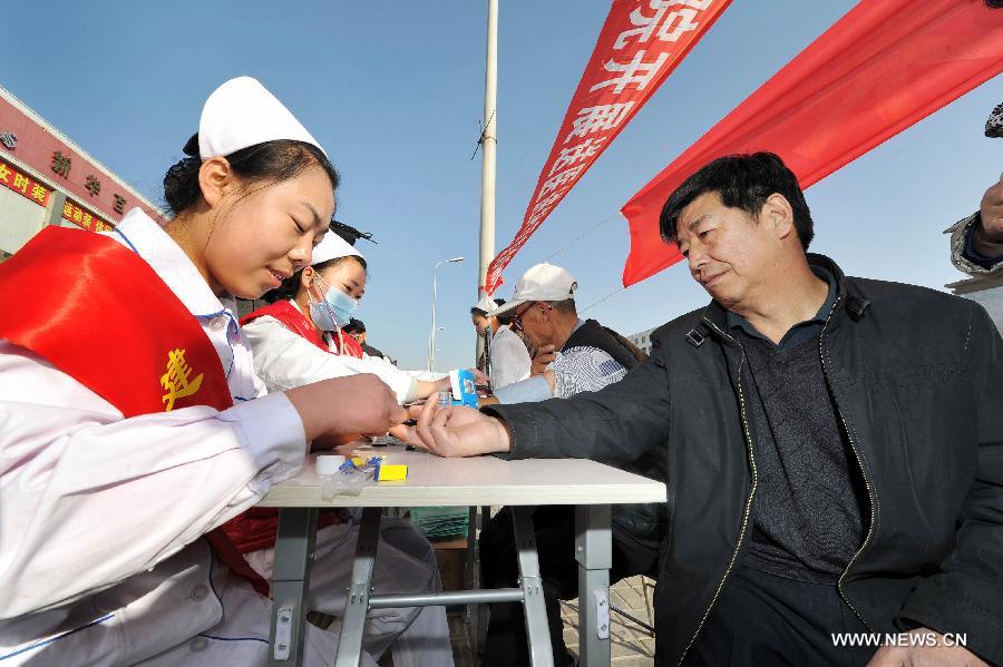 Nurses check the blood glucose for citizens during a free clinic service in Yinchuan,capital of northwest China's Ningxia Hui Autonomous Region, Nov. 14, 2012. An activity of free clinic service was held by Ningxia Chinese Medicine Hospital to welcome the World Diabetes Day on Wednesday. (Xinhua/Peng Zhaozhi)  