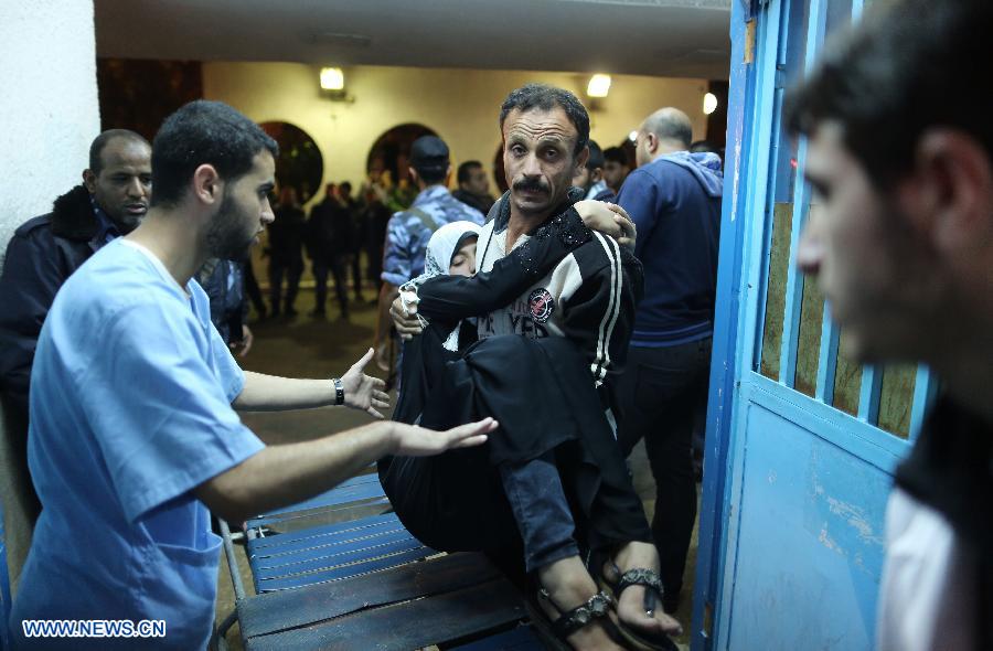 A Palestinian man carries his wounded daughter into a hospital following an Israeli air strike in Gaza City, on Nov. 14, 2012. Israel's air force, after killing Hamas' military leader in an air raid, on Wednesday continued striking Hamas targets, including its long-range rocket sites, in the Gaza Strip. (Xinhua/Wissam Nassar)