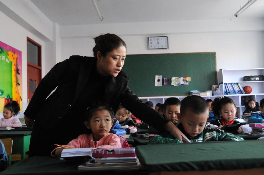 A teacher tutors students with exercise at a primary school in Hegang, northeast China's Heilongjiang Province, Nov. 15, 2012. Students in primary and middle schools in Hegang were back to class on Thursday after two to three days' break which resulted from the heavy snowstorm that hit the city since last Sunday. (Xinhua/Wang Kai) 