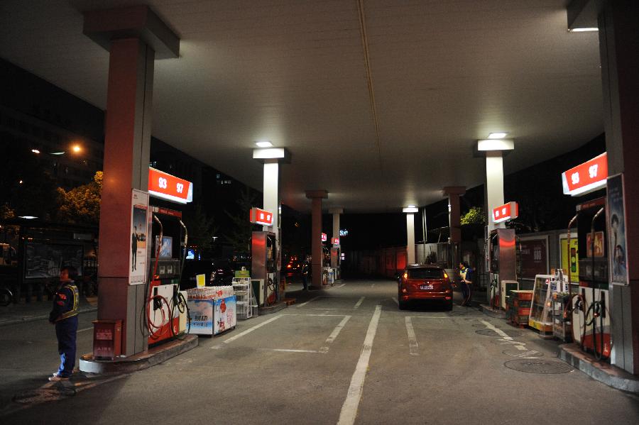 A worker fills a car at a gas station in Hangzhou, capital of east China's Zhejiang Province, Nov. 15, 2012. China will cut the retail prices of gasoline by 310 yuan (49.2 U.S. dollars) and diesel by 300 yuan per tonne starting from Friday, the National Development and Reform Commission (NDRC), the country's top economic planner, said Thursday. (Xinhua/Huang Zongzhi) 