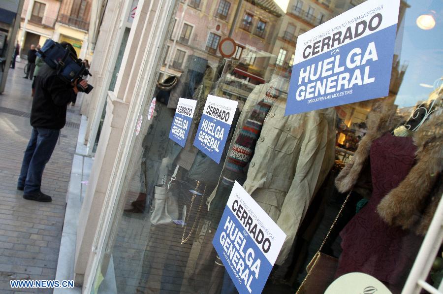 Signs with slogans supporting the general strike are seen in front of a shop during the general 24 hours strike in Malaga, Spain, Nov. 14, 2012. The strike takes place in several areas of the country.(Xinhua)