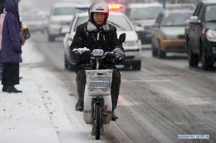 A citizen rides in snow in Changchun, capital of northeast China's Jilin Province, Nov. 16, 2012. A snowfall hit central and eastern Jilin on Friday. (Xinhua/Zhang Nan) 