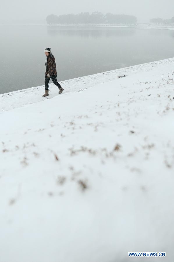 A citizen walks on a snow-covered road in Changchun, capital of northeast China's Jilin Province, Nov. 16, 2012. A snowfall hit central and eastern Jilin on Friday. (Xinhua/Zhang Nan) 