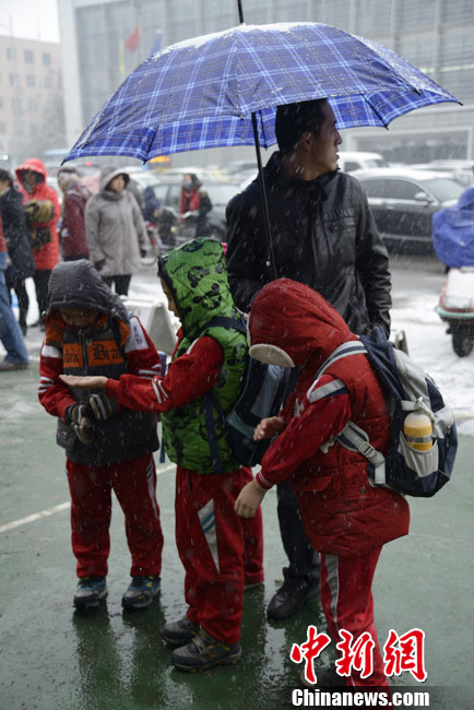 Pictures shows parents picking up children after school in snow in Hohhot on Nov. 15, 2012.(Chinanews/Liu Wenhua)