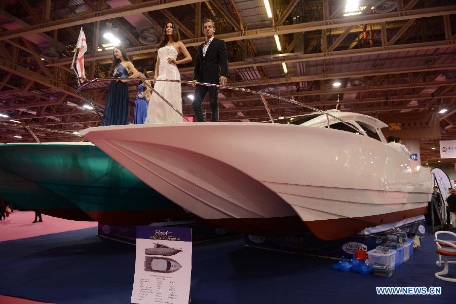 Models present a yacht during the 2012 Macao Yacht Show in Macao, south China, Nov. 16, 2012. More than 30 yacht exhibitors take part in the three-day yacht show, which kicked off here on Friday. (Xinhua/Cheong Kam Ka)