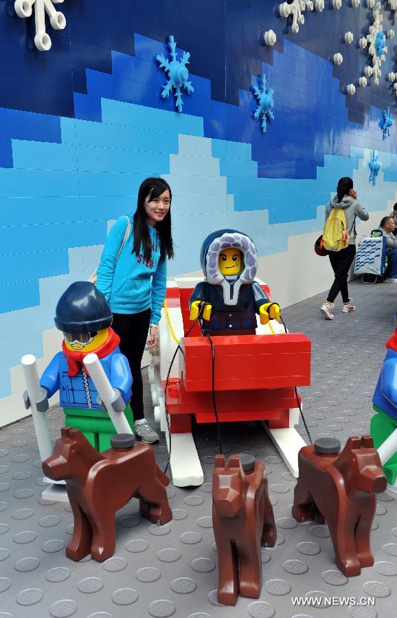 A woman poses for pictures with a sledge built with building blocks at the Times Square in Causeway Bay in south China's Hong Kong, Nov. 16, 2012. As Christmas is drawing near, decorations have been used for creating atmosphere in Hong Kong. (Xinhua/Lo Ping Fai) 