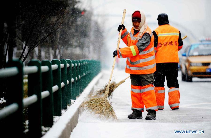 Sanitation workers clean snow in Harbin, capital of northeast China's Heilongjiang Province, Nov. 17, 2012. Another cold front moving eastward will bring more snow to northeast China in the next three days, along with temperature drops and strong winds in some areas, the National Meteorological Center (NMC) forecast on Saturday. (Xinhua/Wang Jianwei) 