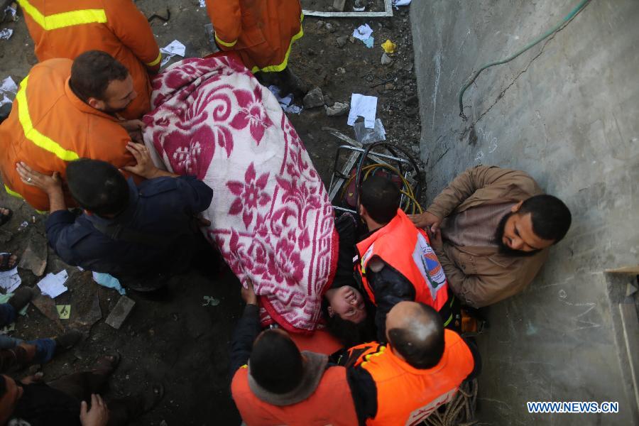 Palestinian civil defense staff members carry a survivor on a stretcher after she was pulled out from the rubble of a destroyed house after an Israeli airstrike on Gaza City, on Nov. 18, 2012. (Xinhua/Wissam Nassar)