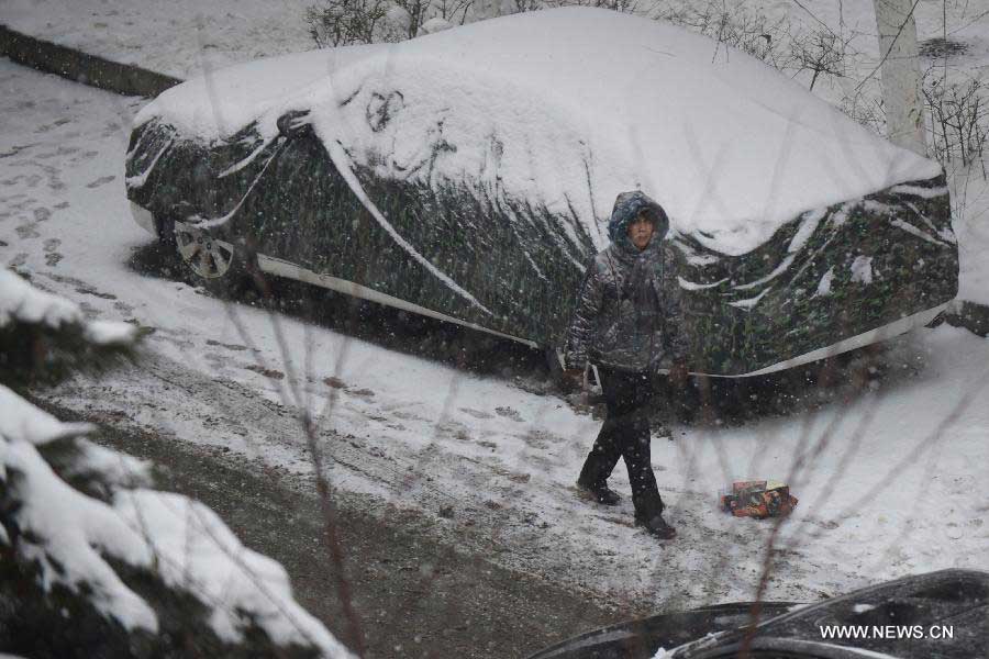 A pedestrian walks in snow in Changchun, capital of northeast China's Jilin Province, Nov. 19, 2012. The local meteorological observatory issued a blue warning for further snowstorms on Monday. (Xinhua/Lin Hong) 