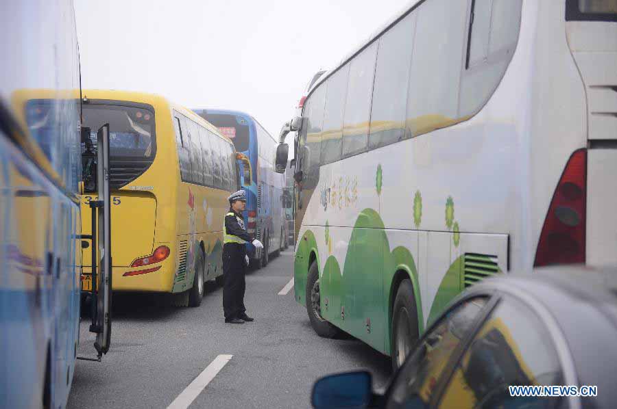 A traffic policeman directs traffic in the Changzhang section of the Shanghai-Kunming Highway in Nanchang, east China's Jiangxi Province, Nov. 19, 2012. The highways which closed because of dense fog in the province gradually reopened as the fog disappeared on Monday morning. (Xinhua/Zhou Mi) 