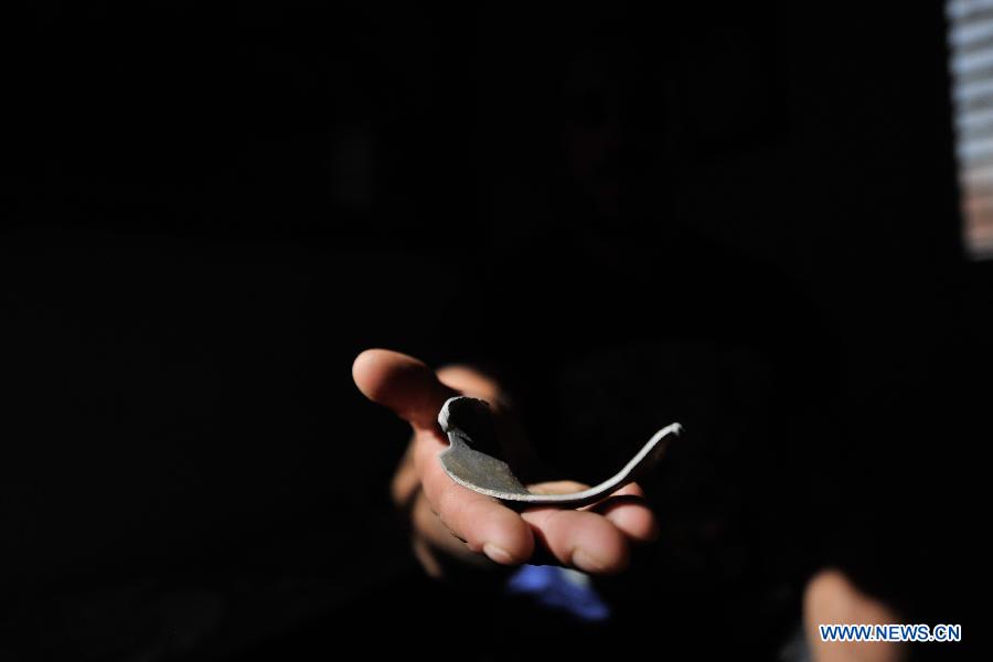 Israeli resident Itsik shows a shrapnel from the Gaza Strip, in Ofakim, South Israel, on Nov.19, 2012. Rocket fire against Israel resumed Monday morning. (Xinhua/Yin Dongxun) 