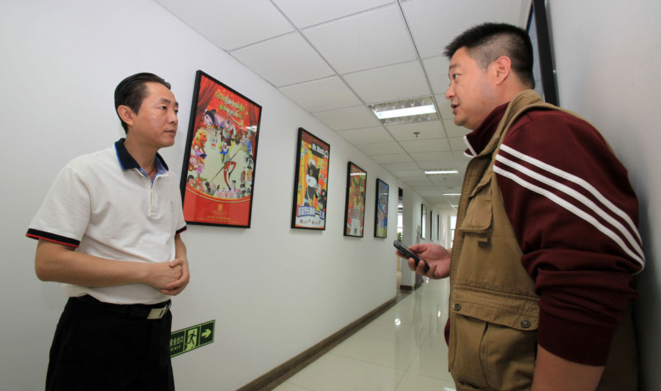 Wang Jin (L), talks with a colleague in the Program Production Center of China ACG Group Co., Ltd in Beijing, capital of China, April 19, 2012. (Xinhua/Meng Chenguang)