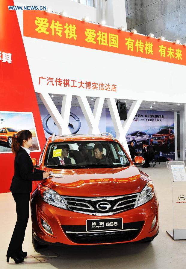 People check a China-made car during the third Harbin autumn automobile exhibition in Harbin, capital of northeast China's Heilongjiang Province, Nov. 20, 2012. The exhibition, as well as the 10th Harbin automobile purchasing week, kicked off on Tuesday.(Xinhua/Wang Jianwei)