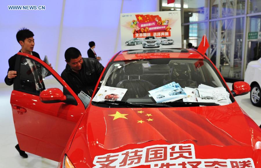 People check a China-made car during the third Harbin autumn automobile exhibition in Harbin, capital of northeast China's Heilongjiang Province, Nov. 20, 2012. The exhibition, as well as the 10th Harbin automobile purchasing week, kicked off on Tuesday.(Xinhua/Wang Jianwei) 