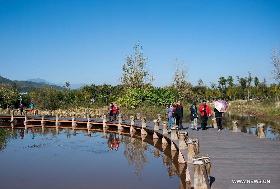 People visit the wetland park at the Qionghai Lake in Xichang City, southwest China's Sichuan Province, Nov. 20, 2012. The Qionghai wetland park attracted many visitors this winter. (Xinhua/Liu Chan)