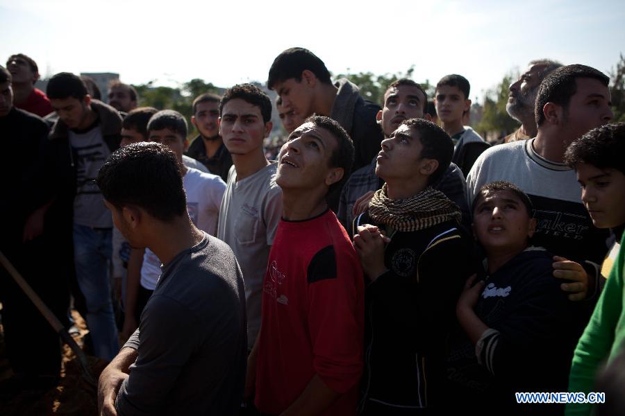 Palestinians watch Israeli F16 fighter jets during a funeral in Gaza City, Nov. 20, 2012. Hamas-run Ministry of Health said the death toll since Wednesday in the Gaza Strip has climbed to 130 and more than 1,000 people were wounded in the ongoing Israeli aerial operation on the coastal enclave. (Xinhua/Chen Xu) 