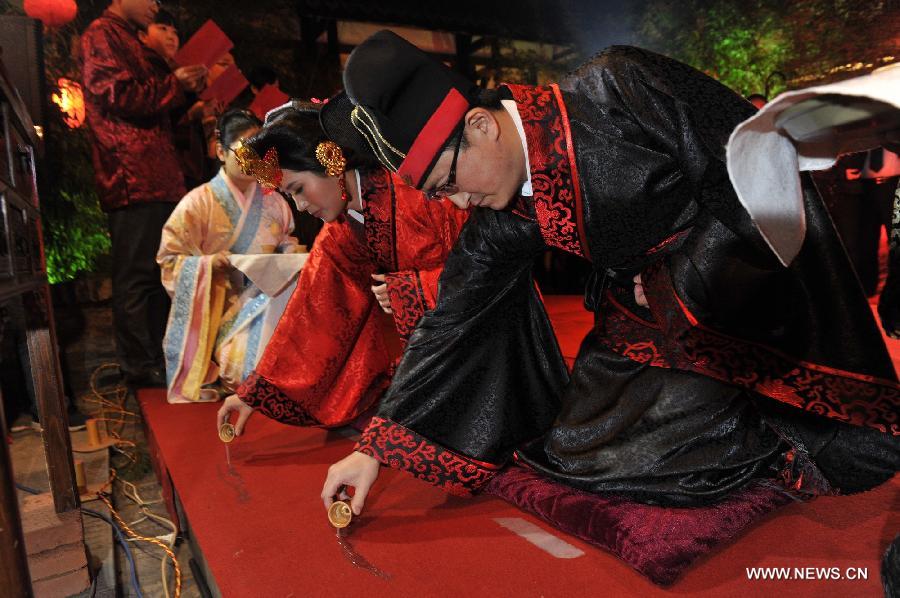 Peng Yong (R) and his bride Chen Yuanyuan sprinkle wine on the ground to pay tribute to the ancestors during a traditional Chinese wedding in Guiyang, capital of southwest China's Guizhou Province, Nov. 19, 2012. The traditional Chinese wedding, pursuant to the etiquettes of the Zhou Dynasties (1046-256BC), sees a resurgence in recent years as the sense of identity grows among modern Chinese couples. (Xinhua/Ou Dongqu) 