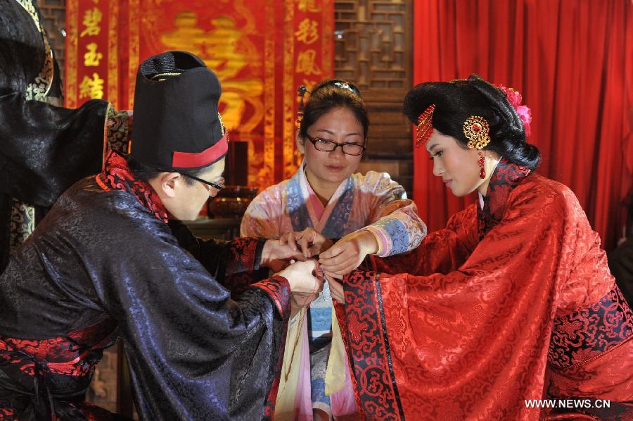 Peng Yong (L) and his bride Chen Yuanyuan (R) attend a ceremony in which the couple officially get married during a traditional Chinese wedding in Guiyang, capital of southwest China's Guizhou Province, Nov. 19, 2012. The traditional Chinese wedding, pursuant to the etiquettes of the Zhou Dynasties (1046-256BC), sees a resurgence in recent years as the sense of identity grows among modern Chinese couples. (Xinhua/Ou Dongqu) 