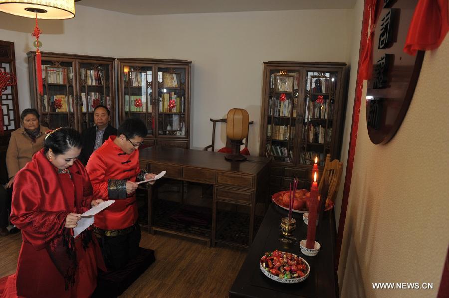 Peng Yong (R, front) and his bride Chen Yuanyuan (L, front) attend a welcome ceremony marking Chen's arrival in the groom's home during a traditional Chinese wedding in Guiyang, capital of southwest China's Guizhou Province, Nov. 19, 2012. The traditional Chinese wedding, pursuant to the etiquettes of the Zhou Dynasties (1046-256BC), sees a resurgence in recent years as the sense of identity grows among modern Chinese couples. (Xinhua/Ou Dongqu) 