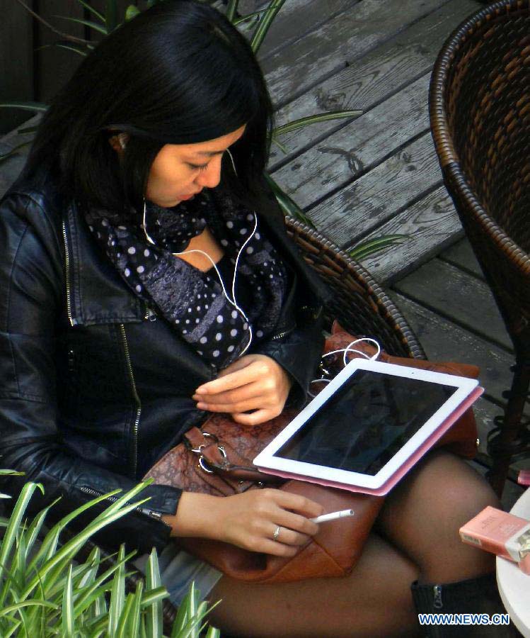 File photo taken on Nov. 12, 2011 shows that a gilr chats online with friends by an Ipad in east China's Shanghai.(Xinhua/Wang Song)