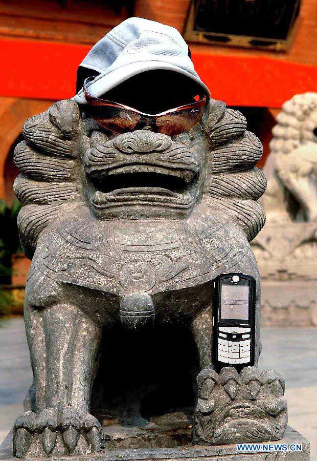 File photo taken on Feb. 28, 2009 shows the necessary items for tourism presented by a tourist: mobile phone, sun glasses and a hat in front of the White Horse Temple in Luoyang, central China's Henan Province. (Xinhua/Wang Song)