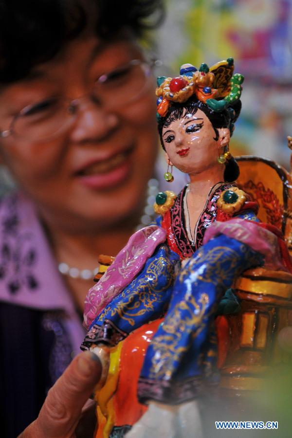 Li Lingxiu shows her clay sculptures in Lanzhou, capital of northwest China's Gansu Province, Nov. 20, 2012. The retired worker Li Lingxiu created 30 clay sculptures of characters in the ancient Chinese novel classic "A Dream of the Red Chamber". (Xinhua/Chen Bin) 