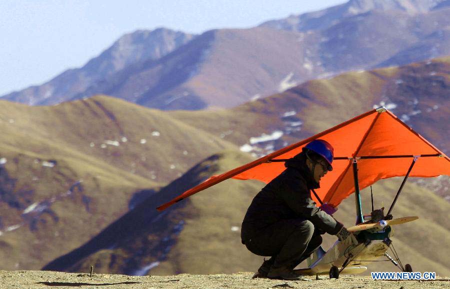 A technicist from the Shandong Electric Power Research Institute (SEPRI) examines an unmanned aircraft which is designed to inspect power transportation lines in regions of high altitude, during a test in Qinghai, a province on the Qinghai-Tibet Plateau, northwest China, Nov. 21, 2012. A research team of the SEPRI has recently conducted a flight test of unmanned aircrafts over the ground with altitude of 4,500 meters, which marks the end of the first round of the unmanned aircraft test project for inspecting power transportation lines on plateaus. (Xinhua) 