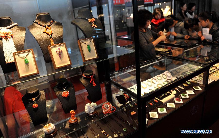 Customers select jade products at Kunming International Jewelry Exhibition in Kunming, capital of southwest China's Yunnan Province, Nov. 22, 2012. The five-day exhibition, which has attracted many exhibitors from southeast Asian countries, will last until Nov. 26. (Xinhua/Lin Yiguang) 