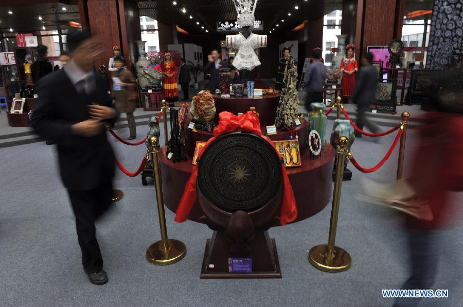 Visitors walk around entries of a competition showcasing handmade craftwork in Guiyang, capital of southwest China's Guizhou Province, Nov. 22, 2012. Some 200 craftsmen showed their skills in the event where exhibited over 570 creations of silverware, batik fabric, embroidery and traditional costumes. The three day competition kicked off here Wednesday. (Xinhua/Ou Dongqu) 