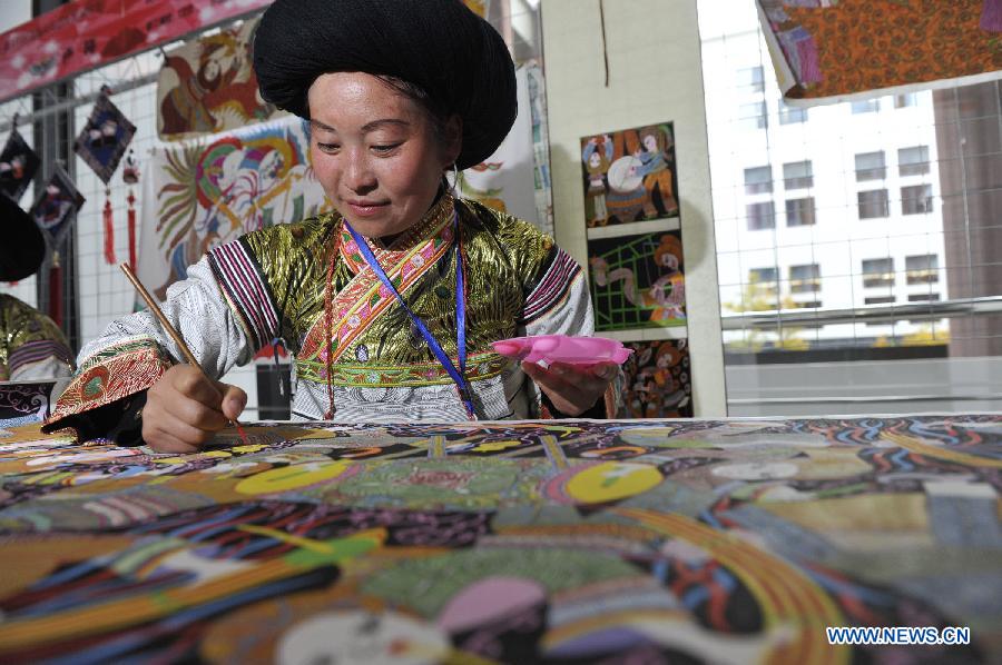 A contestant draws a painting during a competition showcasing handmade craftwork in Guiyang, capital of southwest China's Guizhou Province, Nov. 22, 2012. Some 200 craftsmen showed their skills in the event where exhibited over 570 creations of silverware, batik fabric, embroidery and traditional costumes. The three day competition kicked off here Wednesday. (Xinhua/Ou Dongqu) 