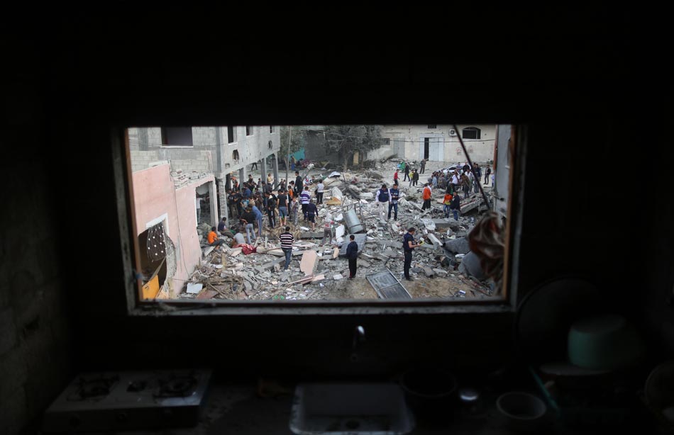 Palestinians gather at the ruins of a refugee camp in northern Gaza City, on Nov. 17, 2012. (Photo/Xinhua)