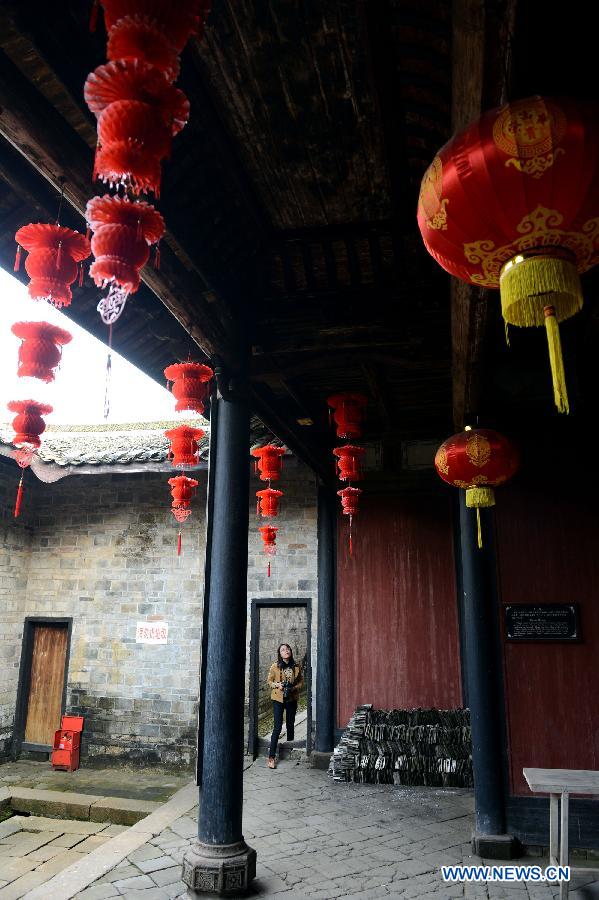 A visitor travels around the ancestral hall of a walled village in Xinwei Village of Longnan County in Ganzhou City, east China's Jiangxi Province, Nov. 20, 2012. The Gannan (southern Jiangxi Province) Hakka walled villages, a special architectural type, was included into China's World Cultural Heritage Tentative List on Nov. 17, 2012. The whole structure of the building resembles a small fortified city, containing halls, storehouses and living areas. It is regarded as the "cradle of Hakka". According to official statistics, there are over 600 such buildings in Gannan at present. (Xinhua/Song Zhenping) 