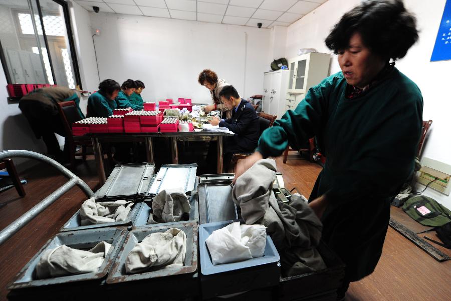 A staff member at the cash center of the Taicang Public Bus Company puts emptied inner sacks of bus fare boxes in Taicang, east China's Jiangsu Province, Nov. 18, 2012. Each day, staff members at the cash center of the Taicang Public Bus Company need to sort out notes and coins collected from all bus fare boxes of the company. It takes four hours on average to finish a day's work: the total earnings of 52 bus lines. (Xinhua/Ji Haixin)