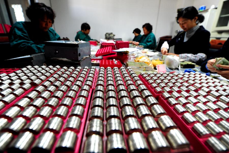 Staff members at the cash center of the Taicang Public Bus Company sort notes and coins at the cash center of the Taicang Public Bus Company in Taicang, east China's Jiangsu Province, Nov. 18, 2012. Each day, staff members at the cash center of the Taicang Public Bus Company need to sort out notes and coins collected from all bus fare boxes of the company. It takes four hours on average to finish a day's work: the total earnings of 52 bus lines. (Xinhua/Ji Haixin)