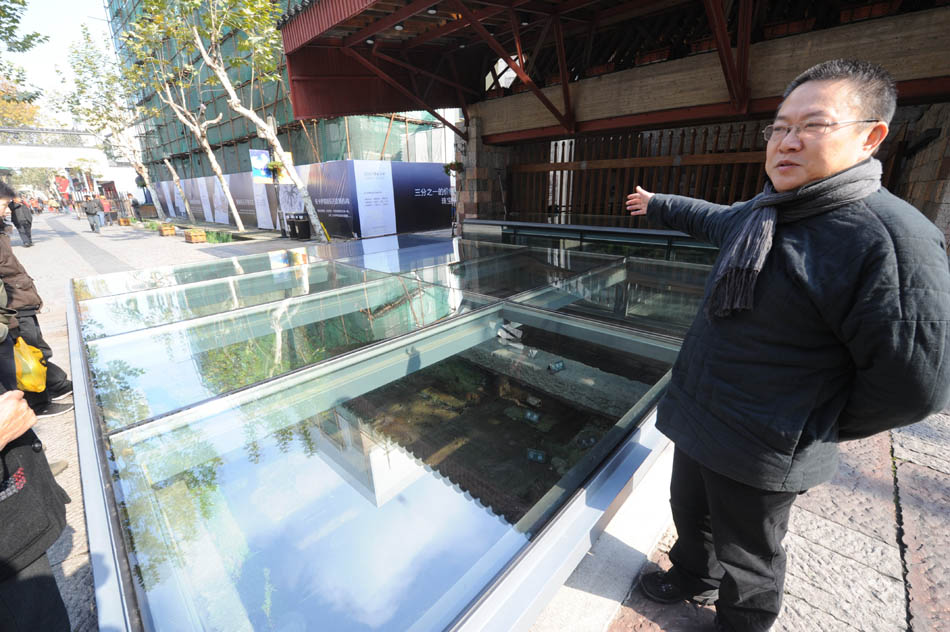 Wang Shu introduces his designing theories besides a relic at the Southern Song Imperial Street, which reserves the characteristics of the Southern Song Dynasty (1127-1279), in Hangzhou, capital of east China's Zhejiang Province, Dec. 9, 2011. (Xinhua/Li Xiaoguo)