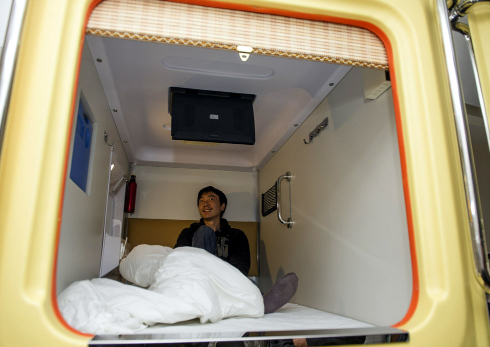 Wang Jun, a traveler in Chongqing watches TV in a “capsule” on Nov.22, 2012.(Xinhua/Chen Cheng)