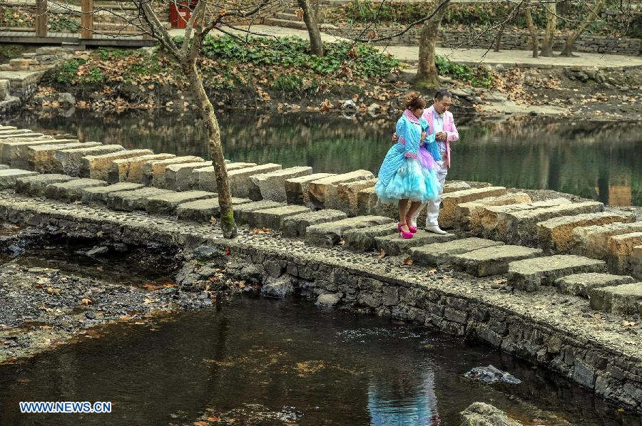 A pair of newlyweds pose for their wedding photo in the Xiaochehe wetland of Guiyang, capital of southwest China's Guizhou Province, Nov. 22, 2012. (Xinhua/Ou Dongqu) 