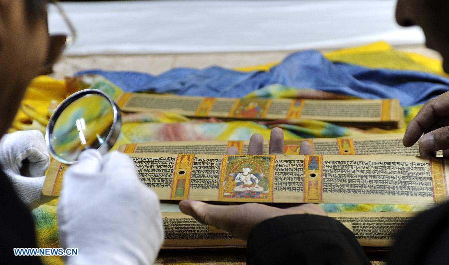 Scholar Ngoizhub Cering (L) studies Palm-Leaf Manuscripts of Buddhist Sutras in Lhasa, capital of southwest China's Tibet Autonomous Region, Nov. 21, 2012. The palm-leaf manuscripts of Buddhist sutras have been well preserved in China. Palm-Leaf sutras refer to the Buddhist classics inscribed on the leaves of palm trees. The practice originated in India and was introduced into China more than 1,000 years ago during the Tang Dynasty (618-907).(Xinhua/Chogo)