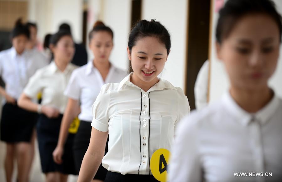 Candidates walk out of the test room after a job interview for airline stewards in Lanzhou, capital of northwest China's Gansu Province, Nov. 24, 2012. The Gansu branch of China Eastern Airline launched a job interview to recruit airline stewards on Saturday, attracting more than 300 applicants.(Xinhua/Zhang Meng) 