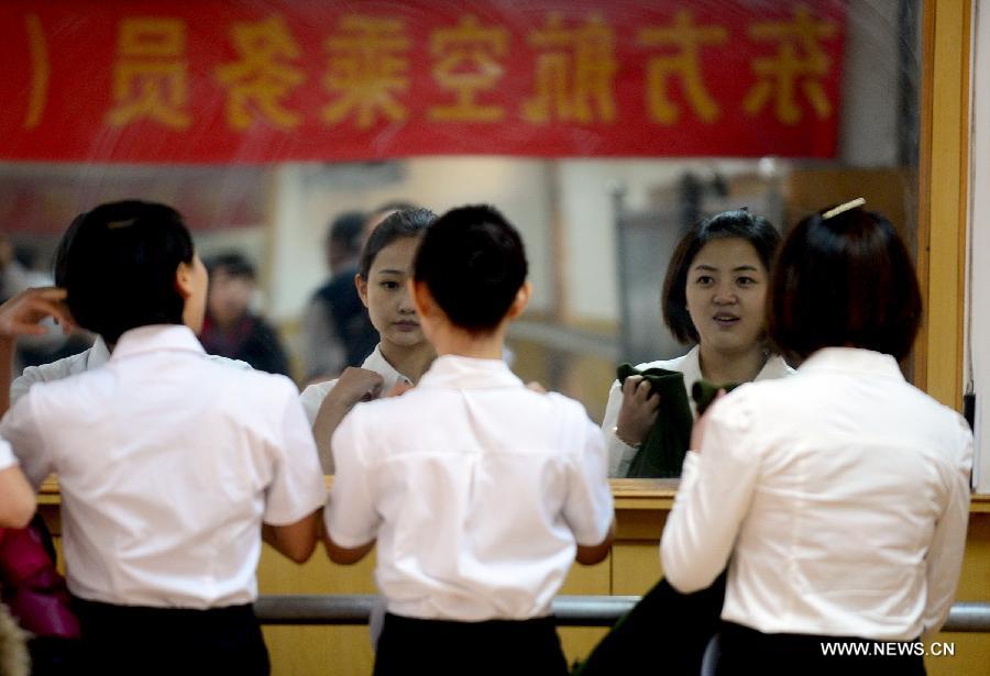 Candidates check their appearance before a job interview for airline stewards in Lanzhou, capital of northwest China's Gansu Province, Nov. 24, 2012. The Gansu branch of China Eastern Airline launched a job interview to recruit airline stewards on Saturday, attracting more than 300 applicants.(Xinhua/Zhang Meng) 