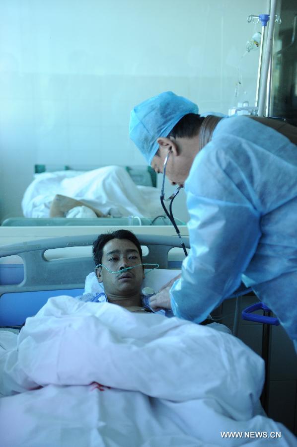 Injured miner Bi Renxiang (L) receives treatment at a hospital in Liupanshui City, southwest China's Guizhou Province, Nov. 25, 2012. Nineteen miners were confirmed dead, five injured and four others remain trapped after a coal-gas outburst hit the Xiangshui Coal Mine at 10:55 a.m. on Saturday.(Xinhua/Tao Liang) 