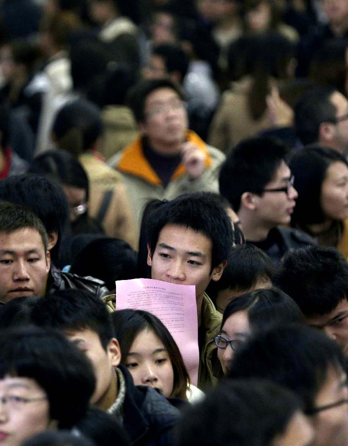 Job hunters cram in the venue of a job fair in Wuhan, capital of central China's Hubei Province, Nov. 24, 2012. The job hunting fair, providing nearly 10,000 vacancies, attracted over 50,000 job seekers on Saturday. (Xinhua) 