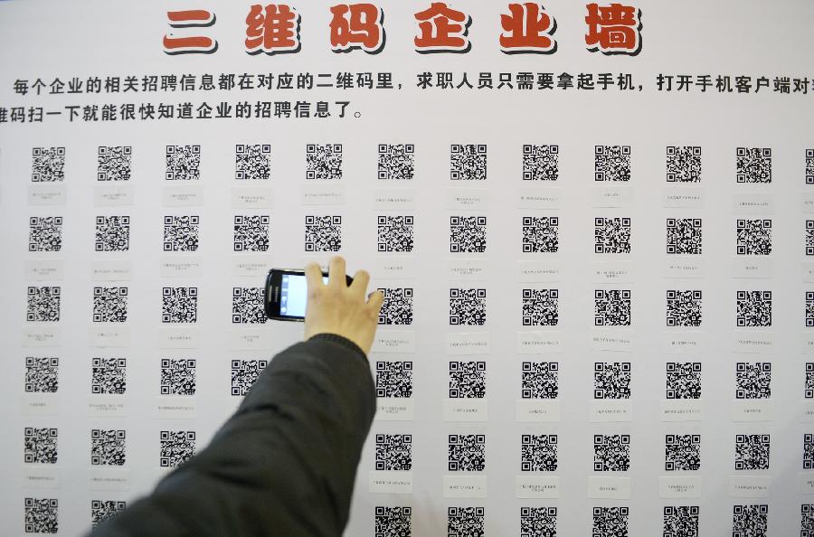 A job seeker scans quick response codes (QR code) with a smartphone to get job information during a job fair in Yinchuan, capital of northwest China's Ningxia Hui Autonomous Region, Nov. 24, 2012. The host of the job fair provided QR codes for the convenience of job seeker.(Xinhua/Wang Peng)