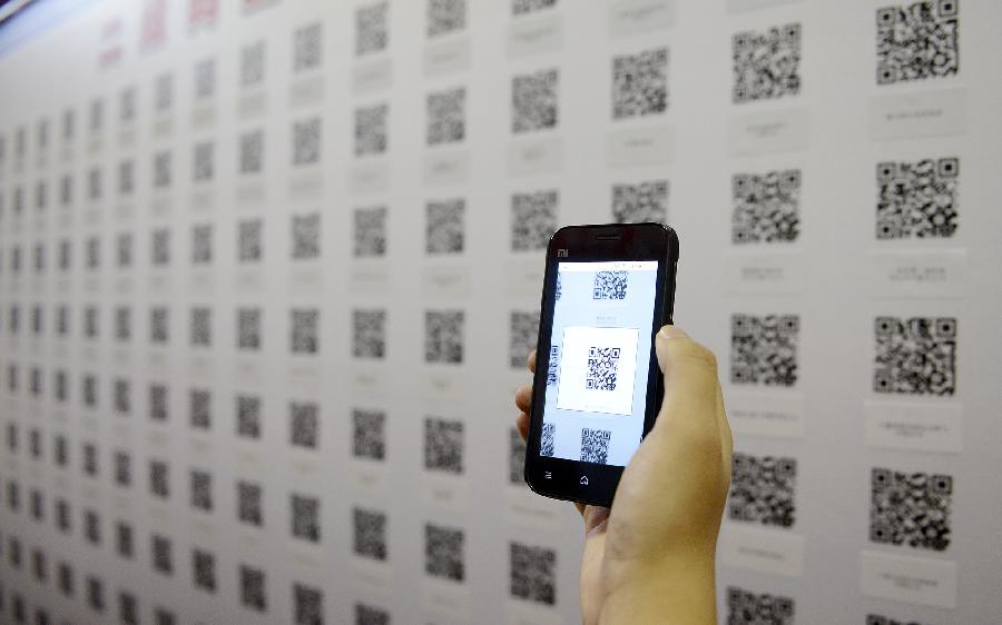 A job seeker scans quick response codes (QR code) with a smartphone to get job information during a job fair in Yinchuan, capital of northwest China's Ningxia Hui Autonomous Region, Nov. 24, 2012. The host of the job fair provided QR codes for the convenience of job seekers. (Xinhua/Wang Peng)