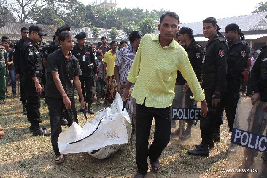 Relatives carry a body from a garment factory where a fire broke out in Saver, outskirts of Dhaka, Bangladesh, Nov. 25, 2012. It is believed that over 100 people died in the accident, said the police. (Xinhua/Shariful Islam) 