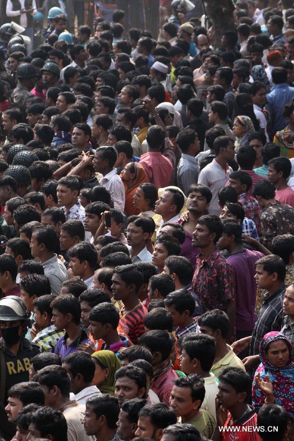 People gather around a garment factory where fire broke out in Saver, outskirts of Dhaka, Bangladesh, Nov. 25, 2012. It is believed that over 100 people died in the accident, said police. (Xinhua/Shariful Islam) 