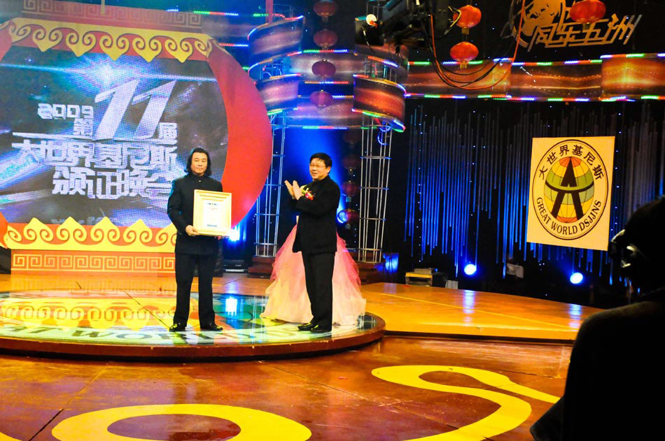 Wang Zhiwen (L) receives an award of China Records for one of his miniature calligraphic creations at a TV studio in Beijing, capital of China, Jan. 11, 2009. (Xinhua/Ke Zhixiong)